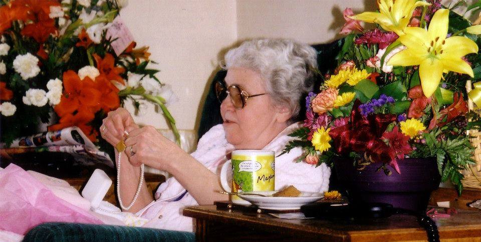 Photo of Mom surrounded by flowers from loving family